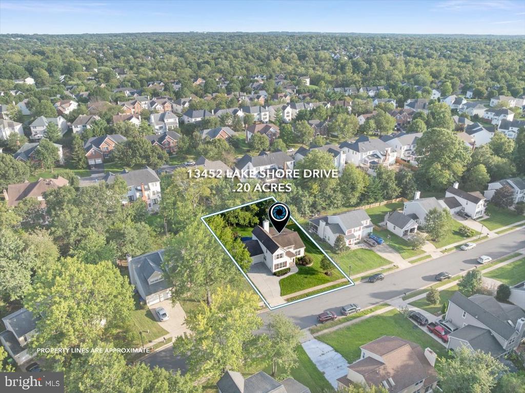 Aerial view of a Herndon home and its outlined 0.20-acre lot in a wooded neighborhood.