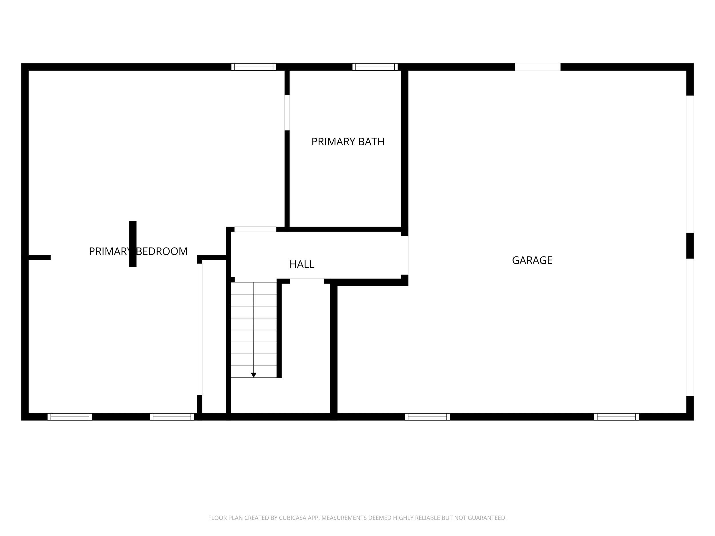 Floor plan showing a primary bedroom, bath, hall, staircase, and garage.