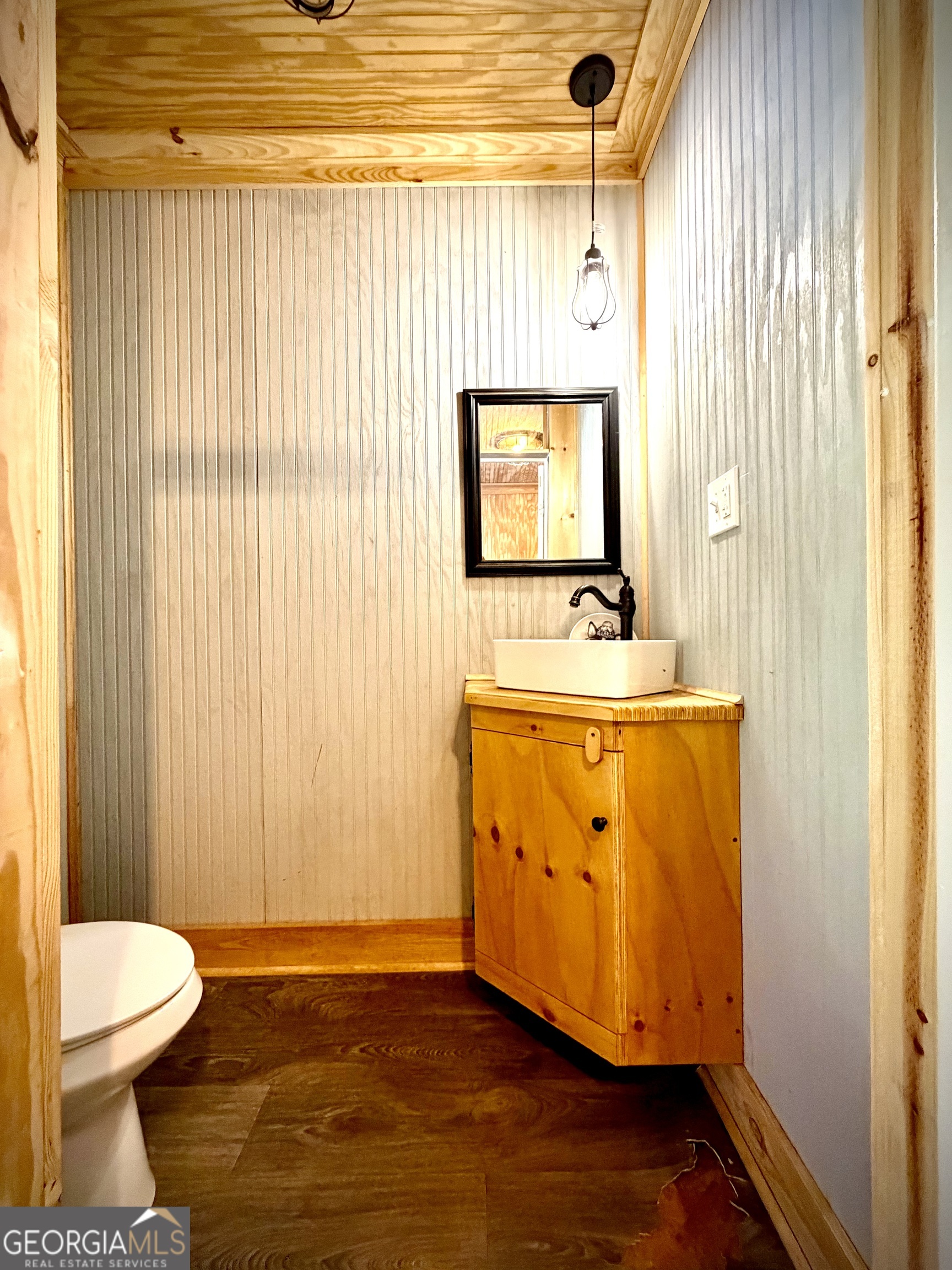 Bathroom with a wood vanity and vessel sink, beadboard walls, and a wood-plank ceiling.