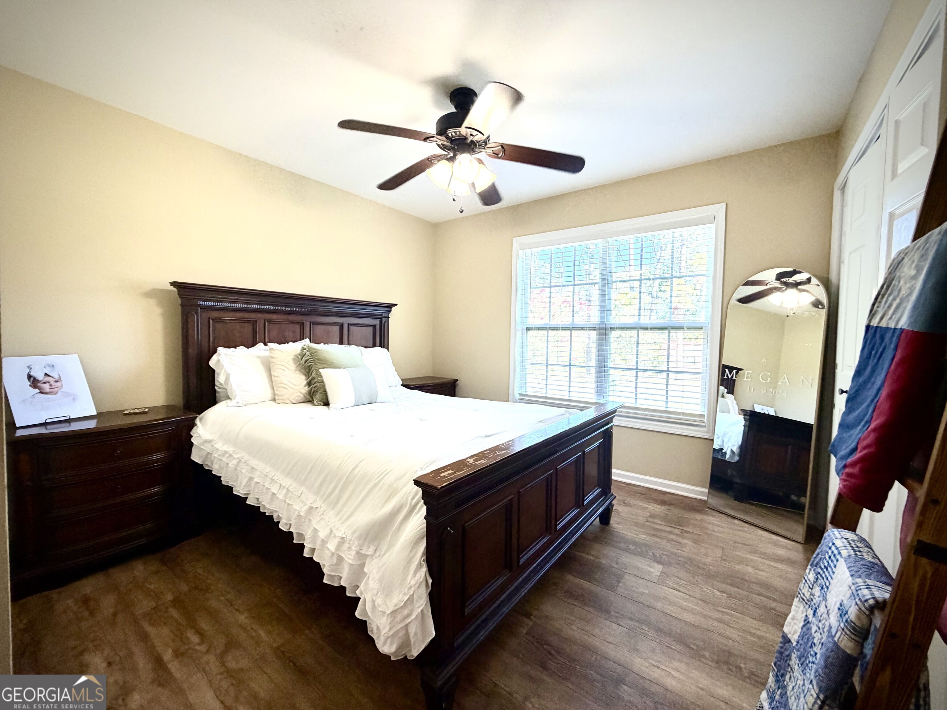 Furnished bedroom with a dark wood bed, white bedding, and a ceiling fan.
