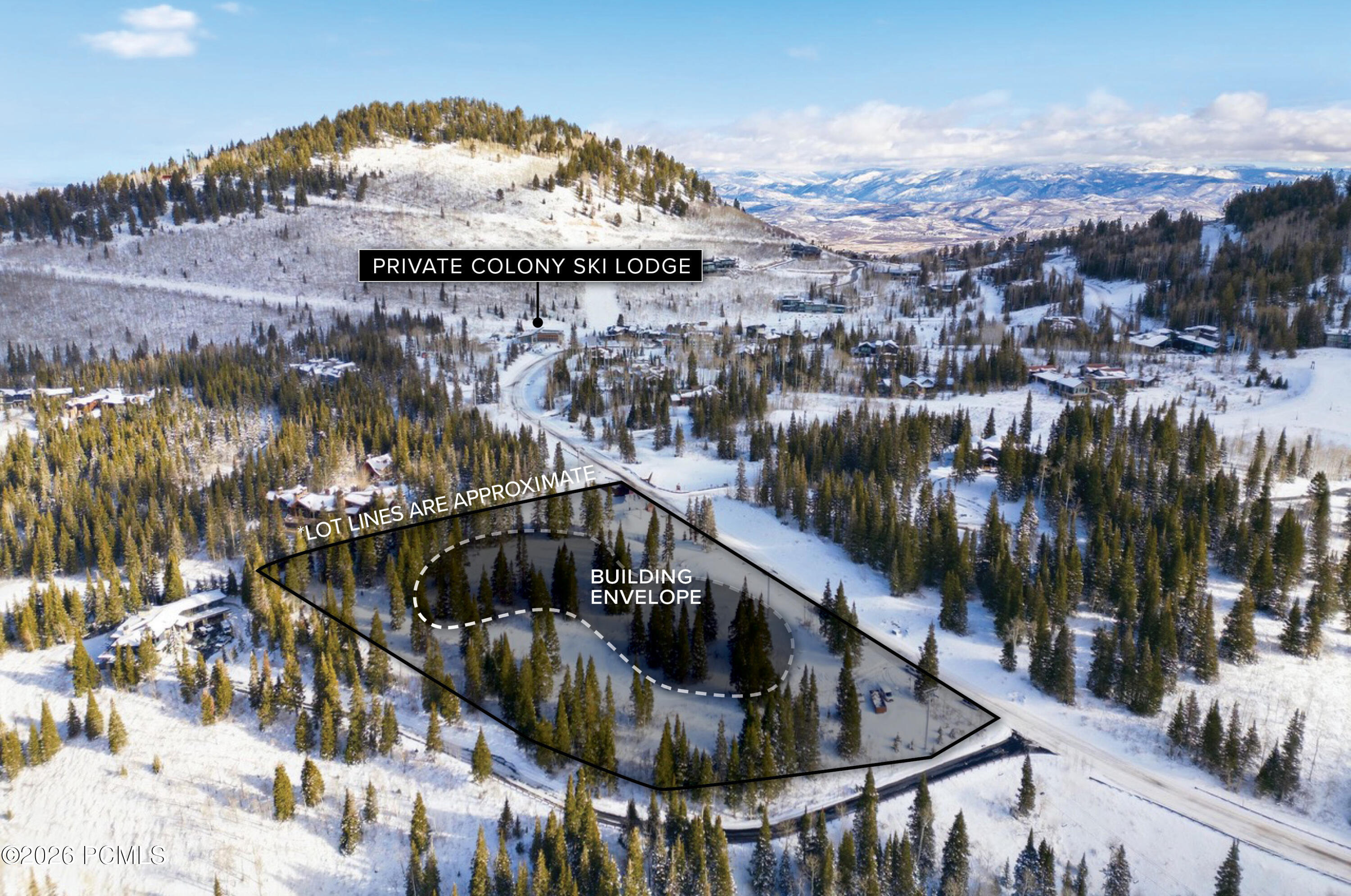 Aerial view of a snow-covered wooded lot marked with approximate boundaries and a building envelope.