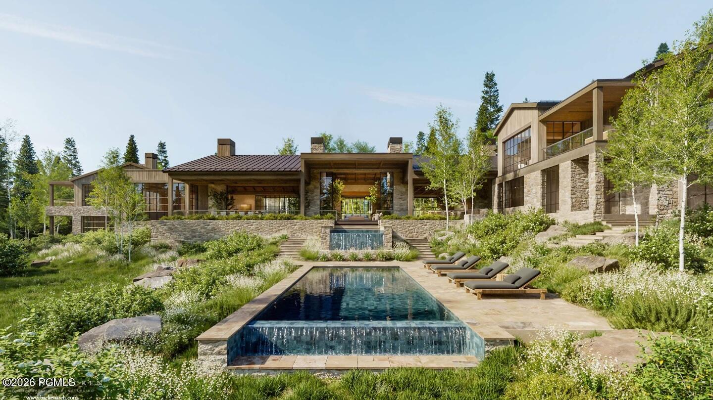 Modern stone-and-timber home behind a long pool with a waterfall edge and landscaped grounds.