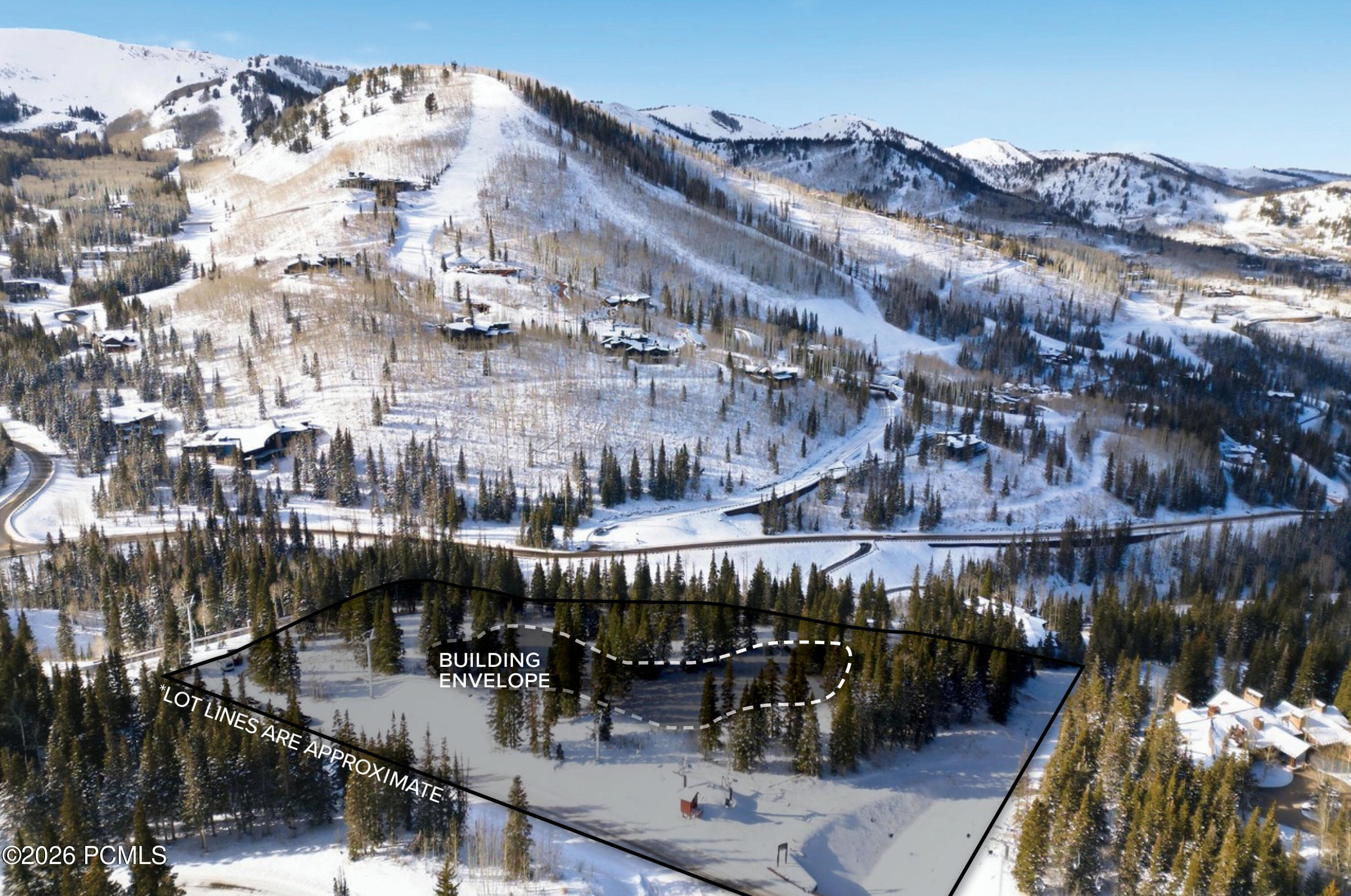 Aerial view of a wooded snowy lot with approximate boundaries and a marked building envelope.