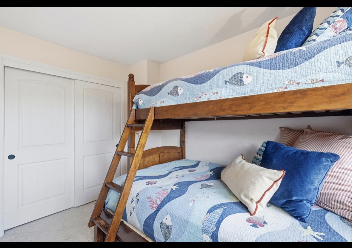 Bedroom with a wooden bunk bed and blue fish-patterned quilts.