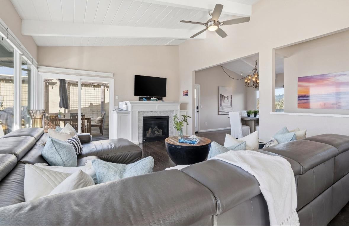 Living room with a gray sectional, fireplace, and sliding doors to a covered patio.