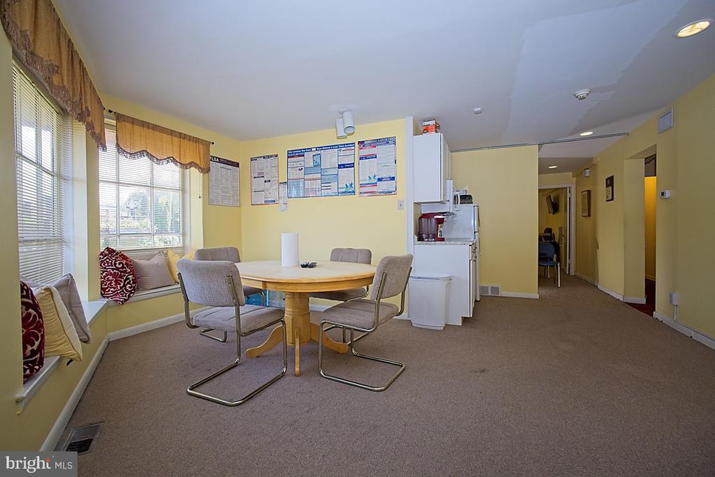 Furnished kitchenette with a round table, window seats, and refrigerator, microwave, and coffee maker.
