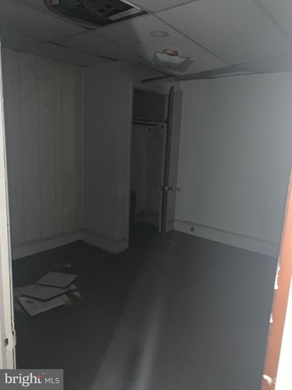 Vacant room with an open closet and damaged ceiling panels.
