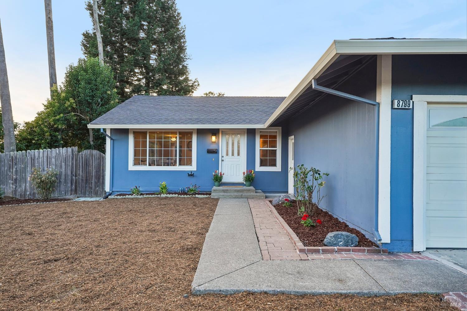 Blue single-story home with white trim, attached garage, and a walkway leading to the front door.