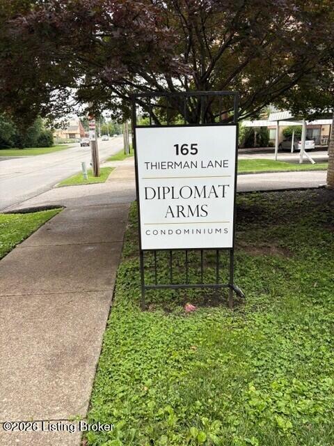 Diplomat Arms Condominiums sign at 165 Thierman Lane beside a sidewalk.