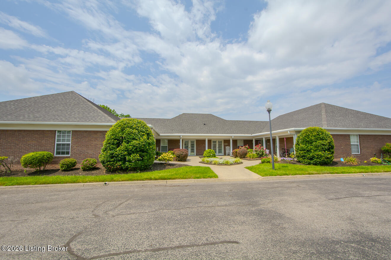 Single-story brick building with a covered entrance and landscaped front lawn.
