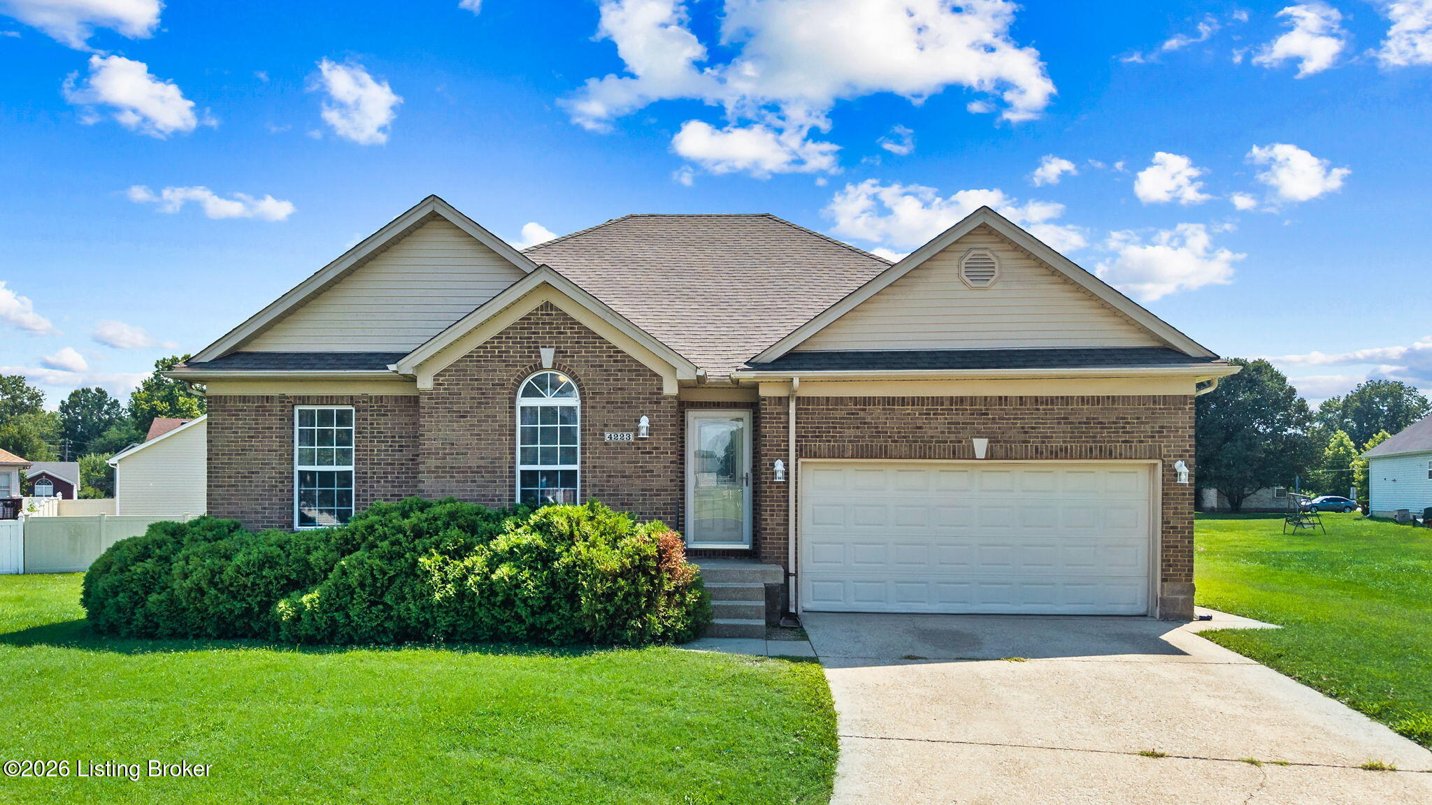 Brick-and-siding ranch home with an attached two-car garage and broad front lawn.
