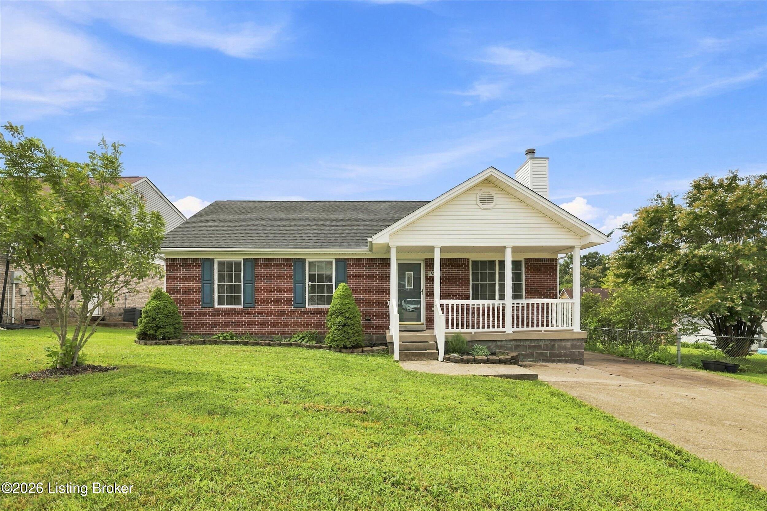 Brick ranch house with a white covered porch, front lawn, and driveway.