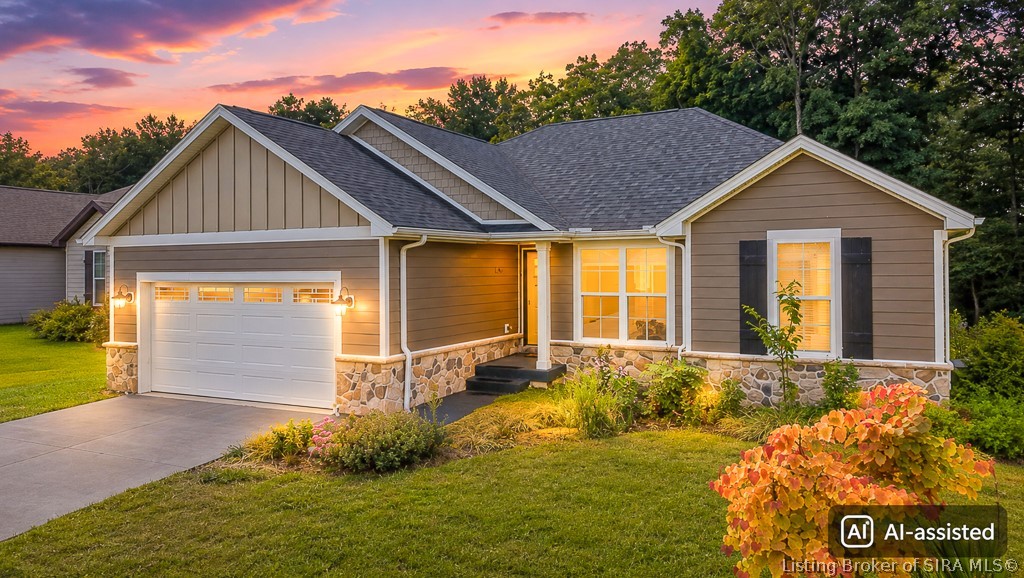 Taupe single-story home with stone accents and a white garage door at dusk.