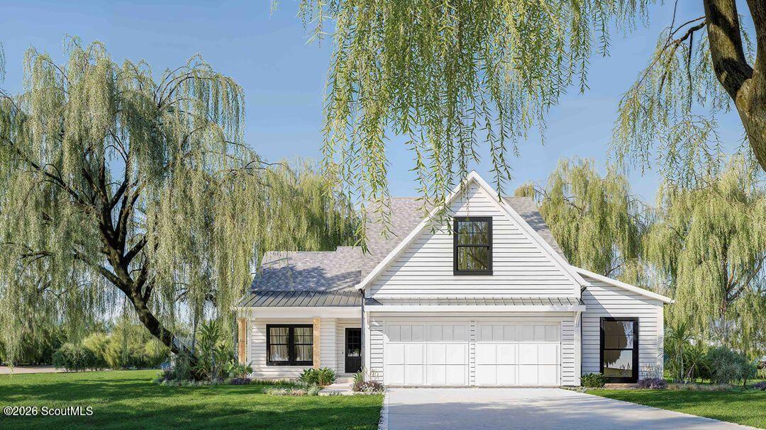 White-sided house with a two-car garage and driveway framed by mature weeping willows.