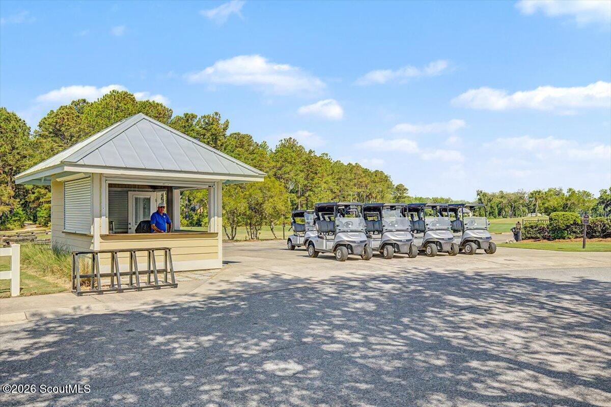 Golf carts parked beside a small golf course attendant kiosk.