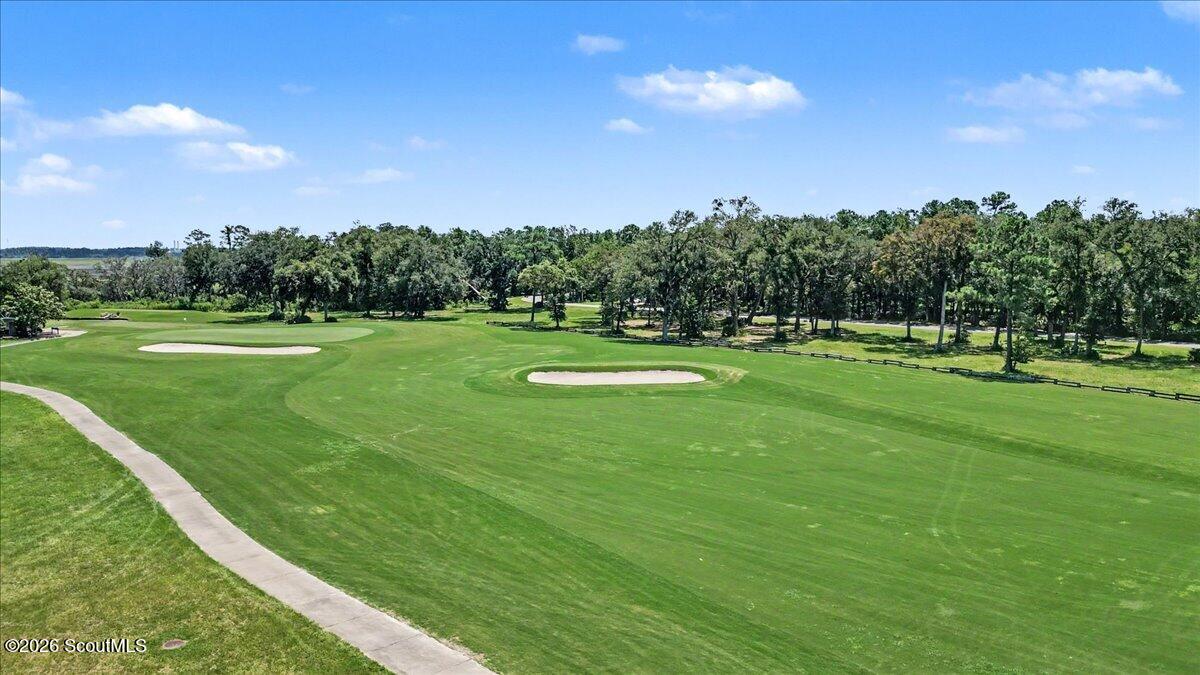 Panoramic golf course with sand bunkers, a curving cart path, and trees.