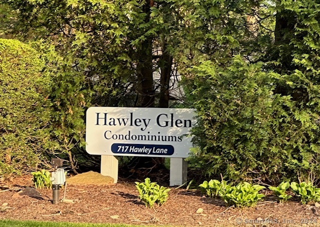 Hawley Glen Condominiums sign at 717 Hawley Lane, surrounded by greenery.