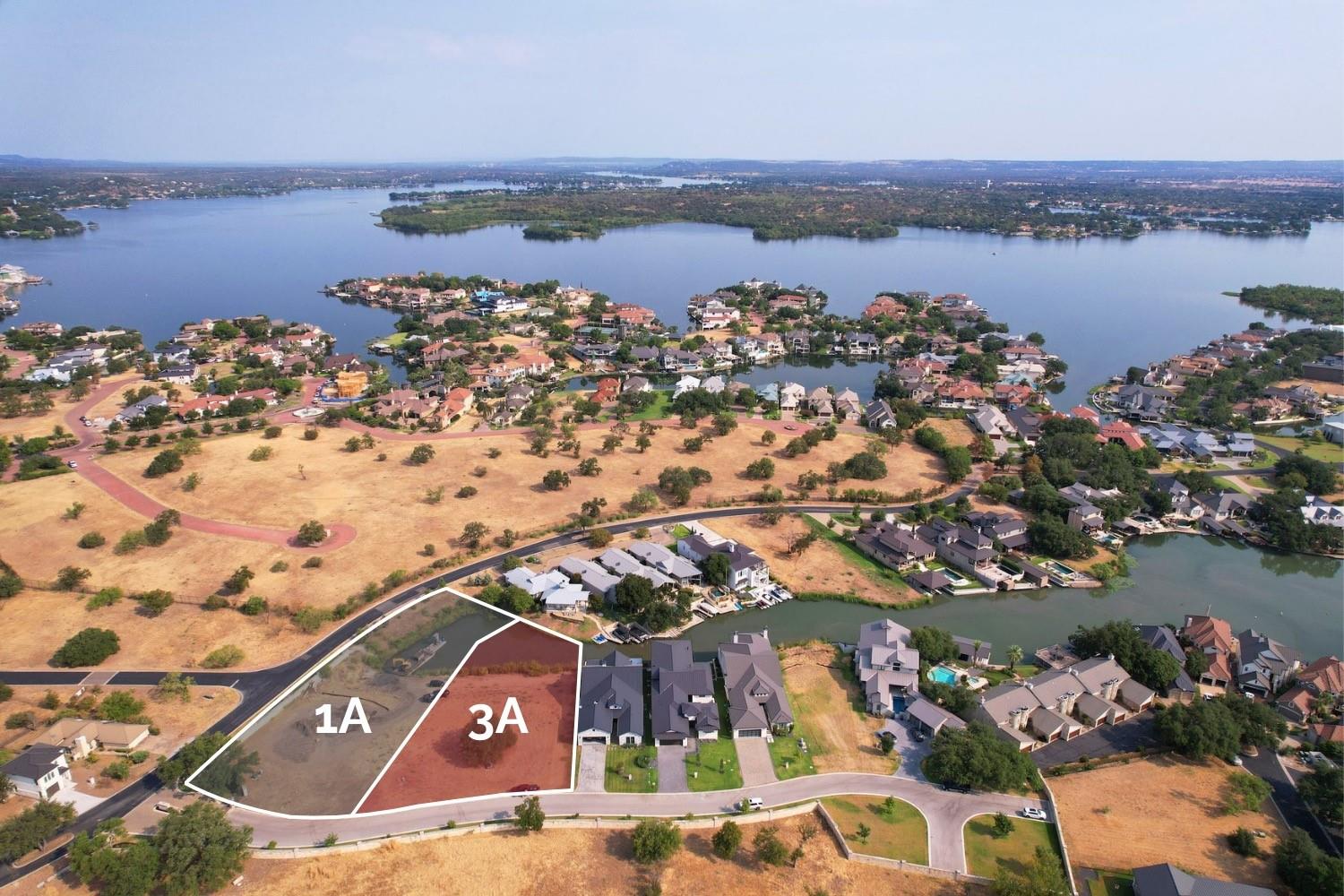 Aerial view of outlined lots 1A and 3A beside a lake and residential neighborhood.
