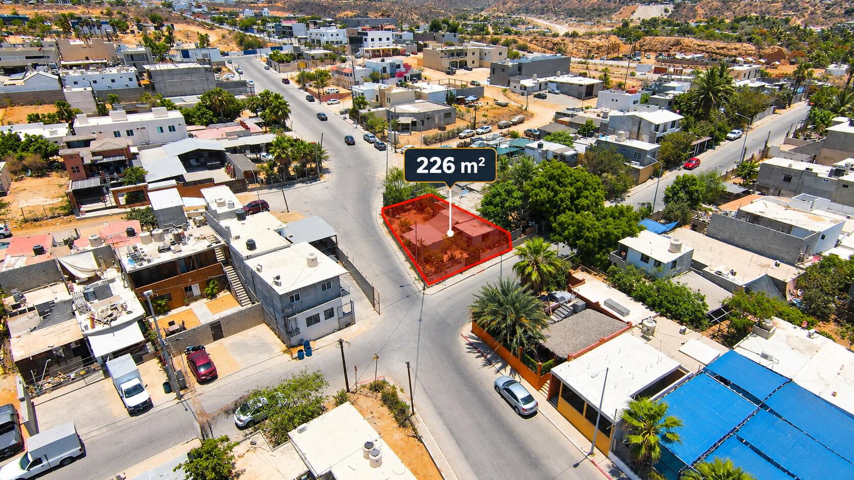 Aerial view of a highlighted 226-square-meter property on a neighborhood street corner.