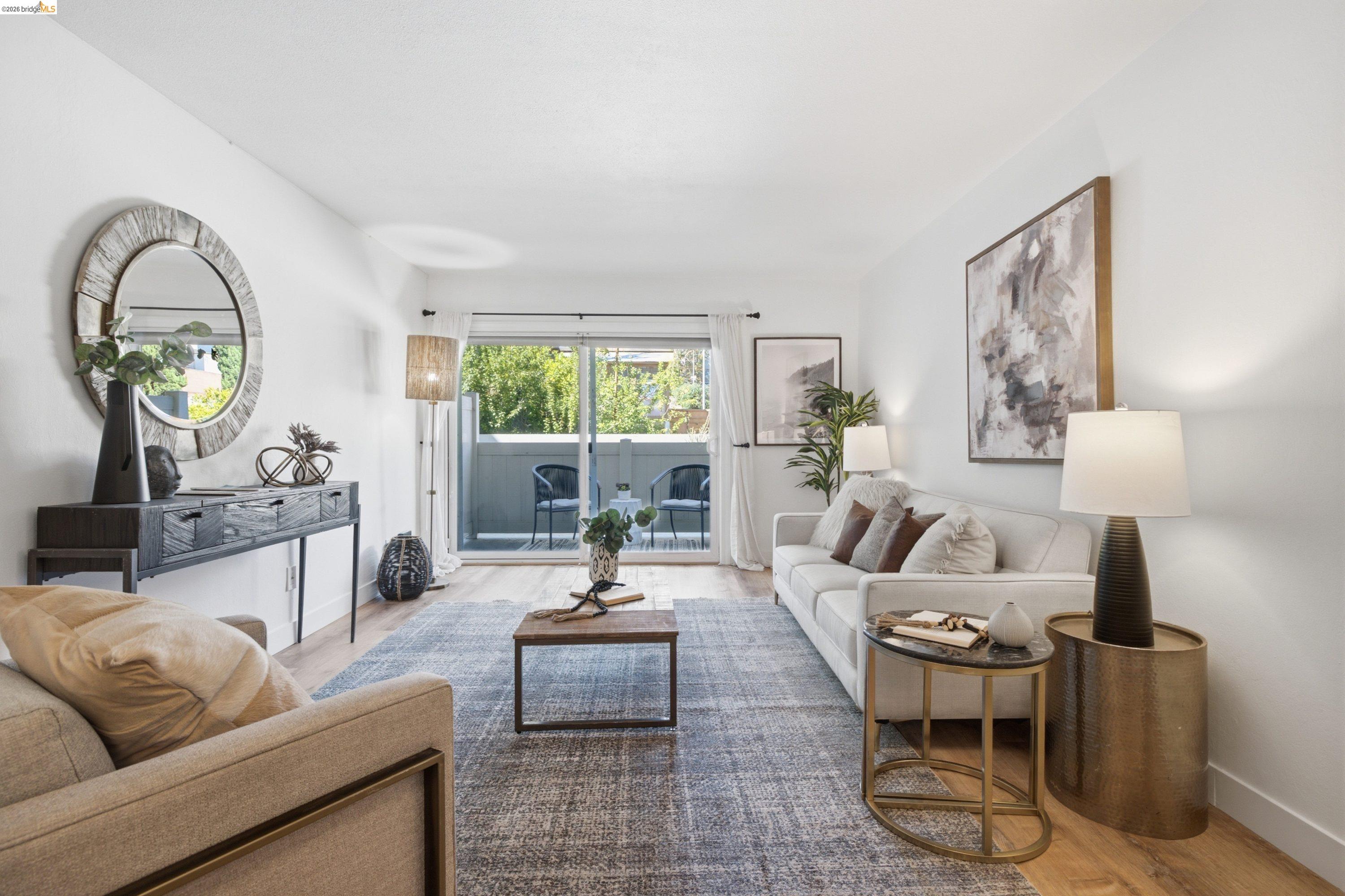 Staged living room with a white sofa and sliding doors opening to a balcony.