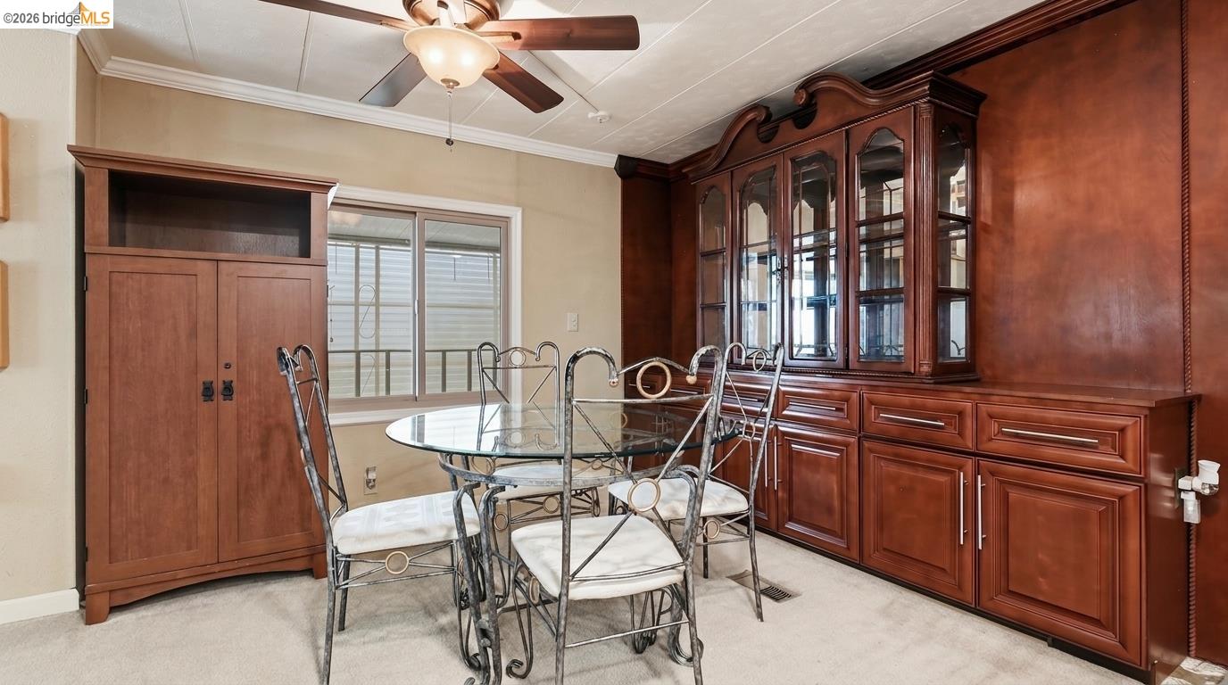 Dining room with a glass-top table, metal chairs, and a large dark wood built-in cabinet.