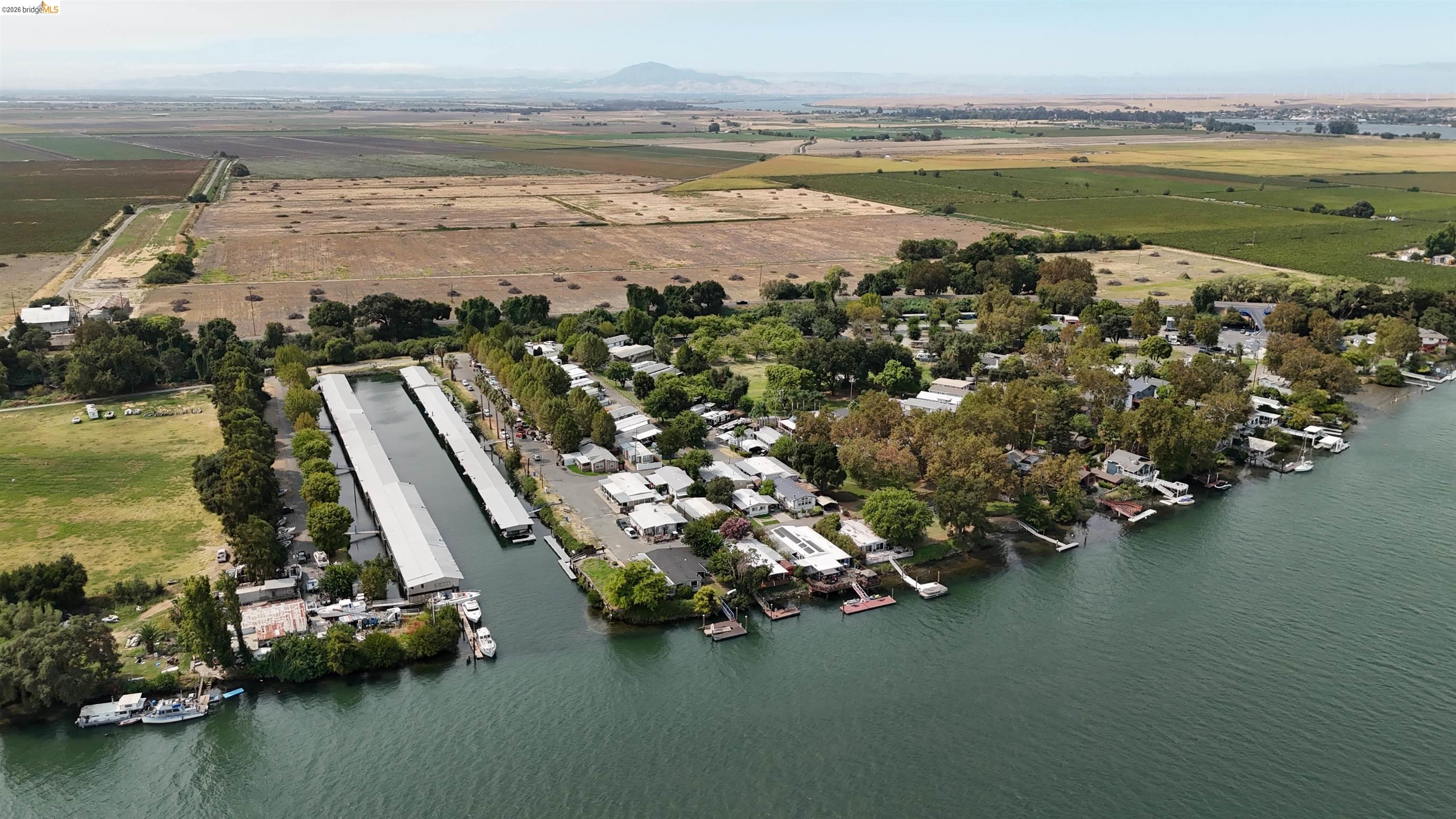 Aerial view of a waterfront community with homes, docks, and a long marina canal.