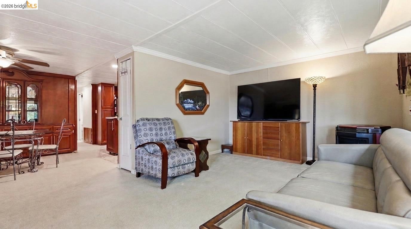 Living room with a gray sofa, patterned armchair, and adjoining dining area.