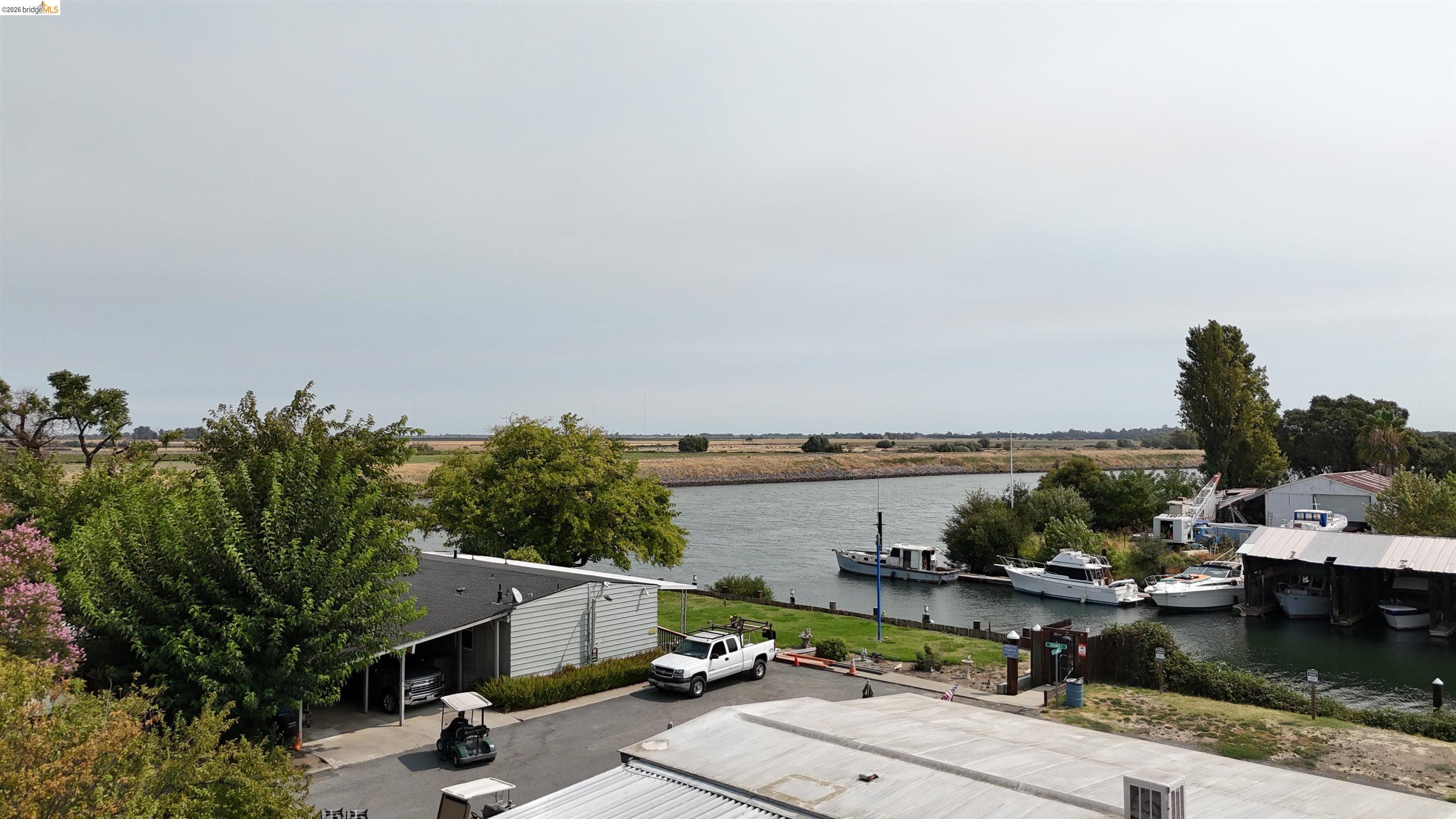 Waterfront property beside a marina, viewed from above with boats moored along the channel.