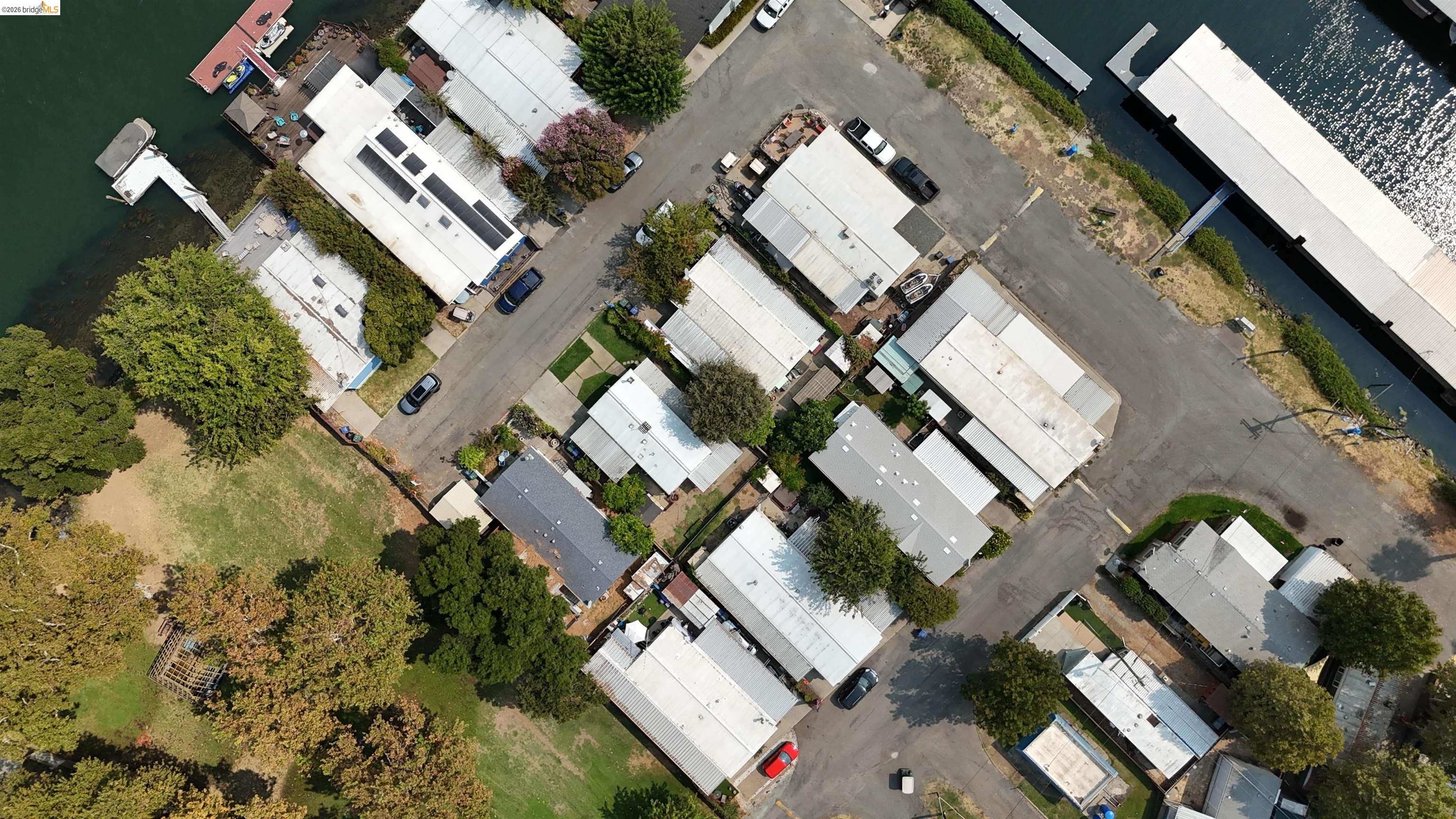 Aerial view of waterfront homes, docks, and parking beside a channel.