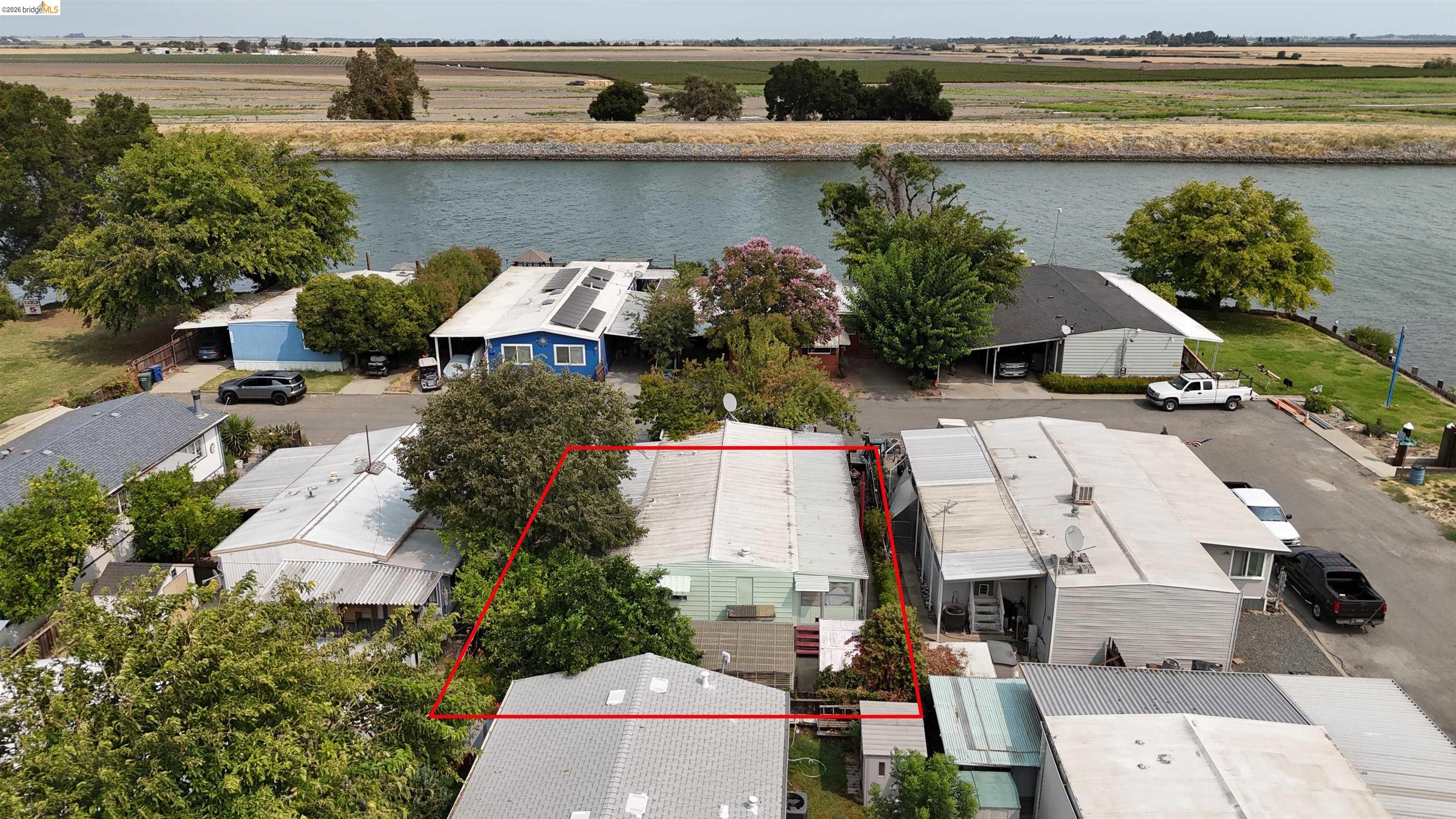 Aerial view of the outlined canal-side home among neighboring houses.