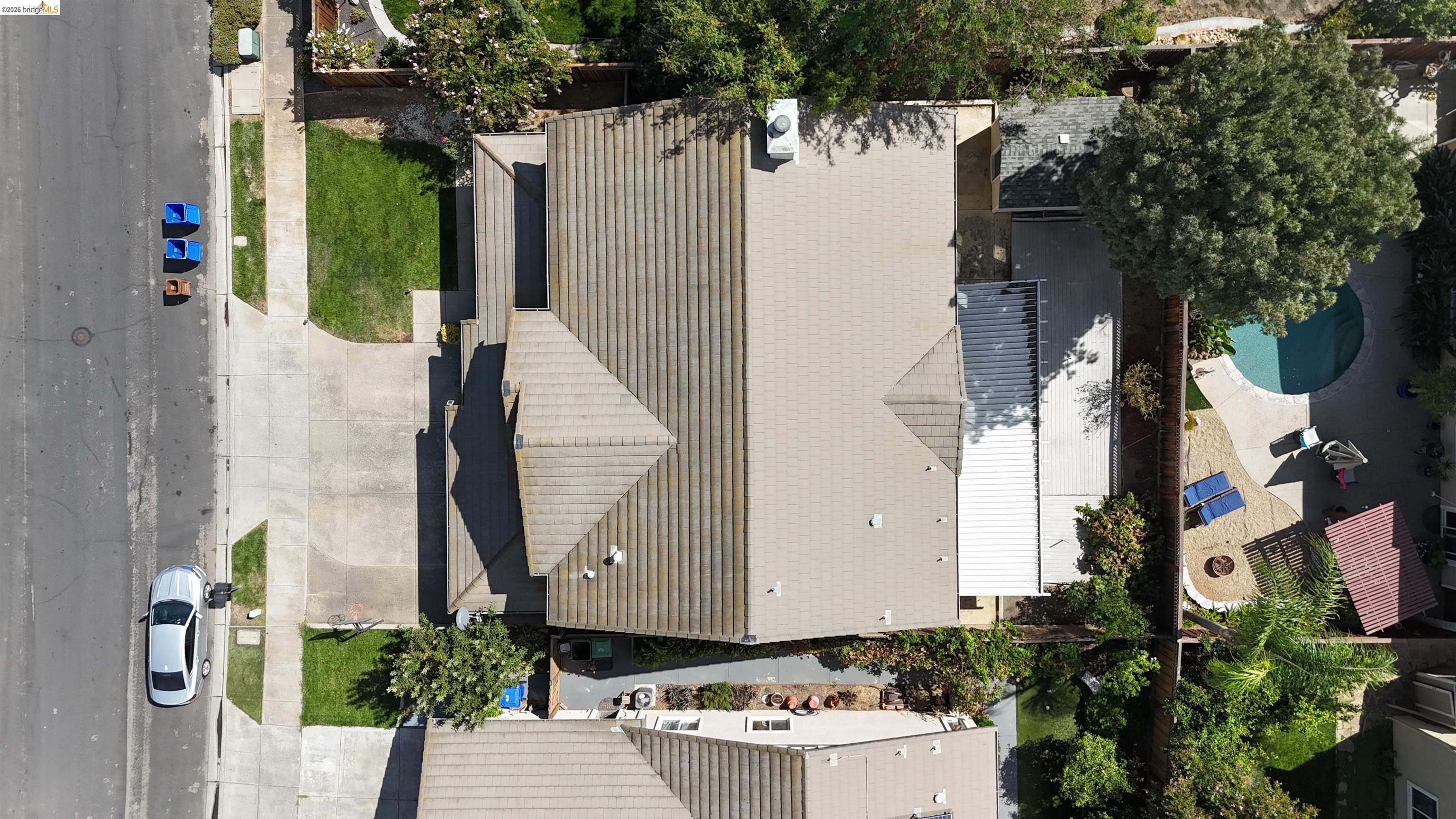 Aerial view of the house, driveway, lawn, and backyard pool.