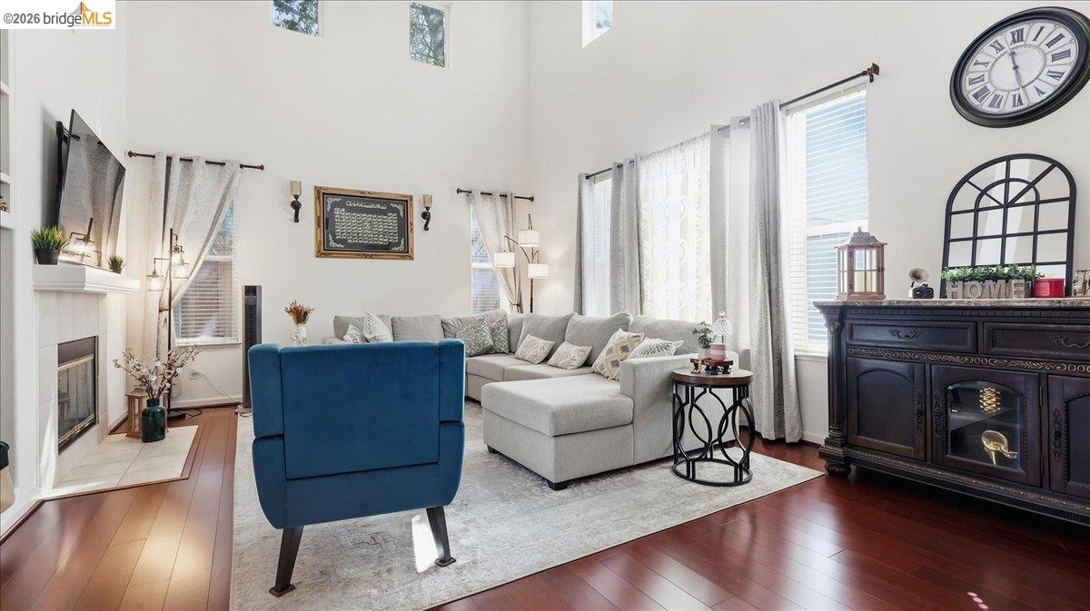 Living room with vaulted ceiling, fireplace, gray sectional, and blue armchair.
