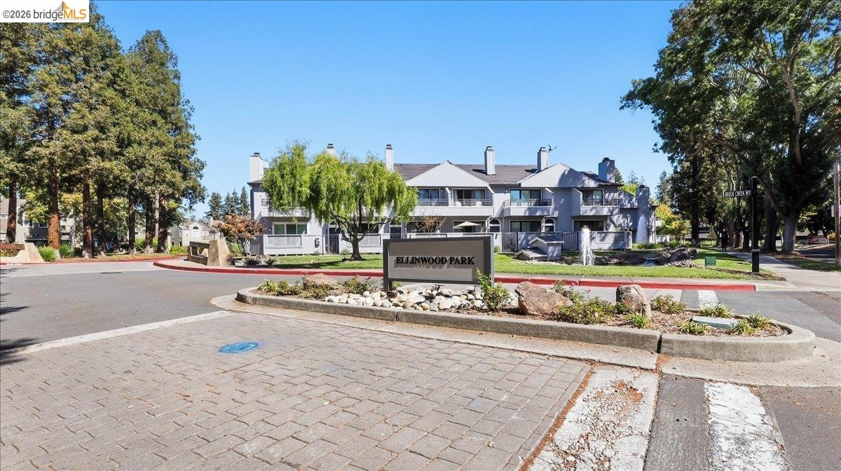 Elmwood Park residential complex behind its landscaped entrance sign on a sunny day.
