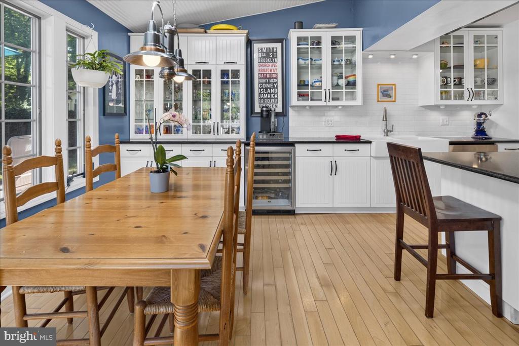 Kitchen and dining area with white cabinetry, blue walls, and a long wooden table.