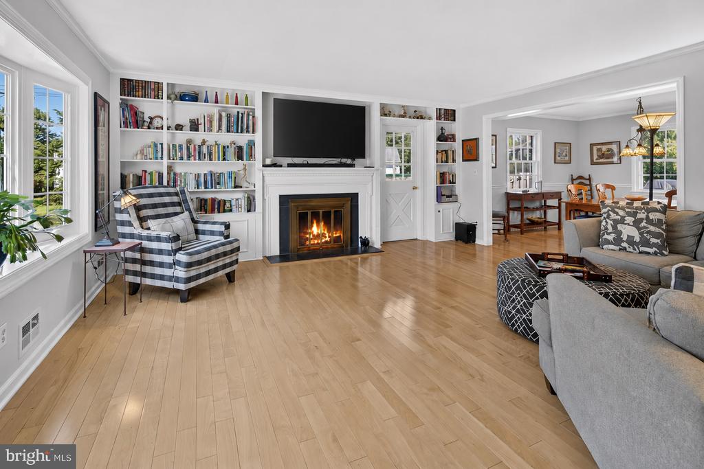 Living room with built-in bookshelves, a fireplace, and an adjoining dining area.