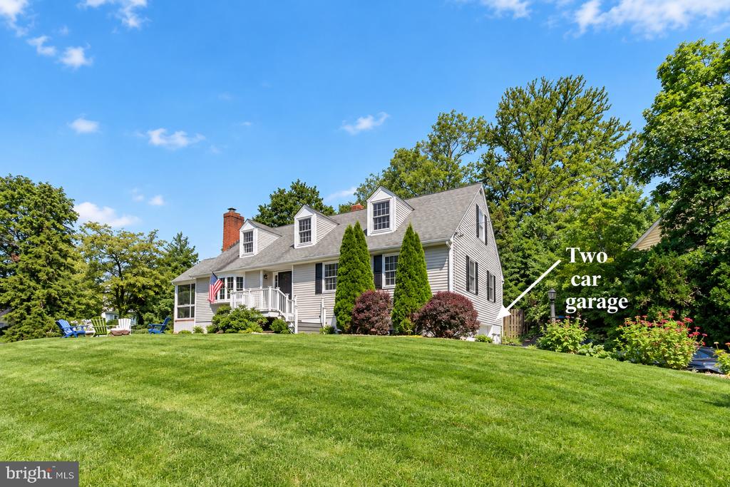 Gray-sided house with dormer windows, a front porch, and a labeled two-car garage.
