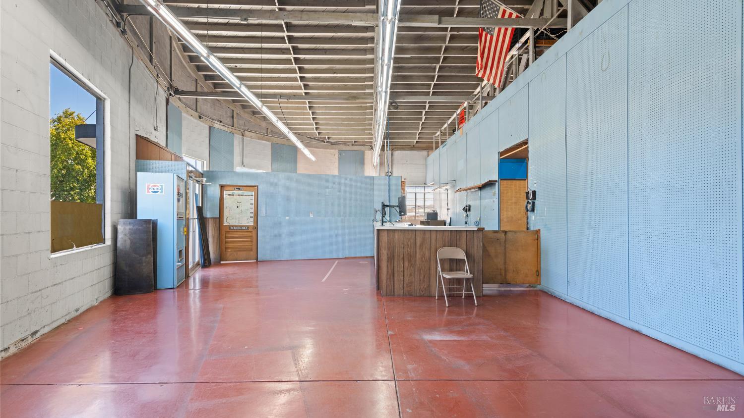 Commercial interior with blue partition walls, red floor, and a wood-front counter.