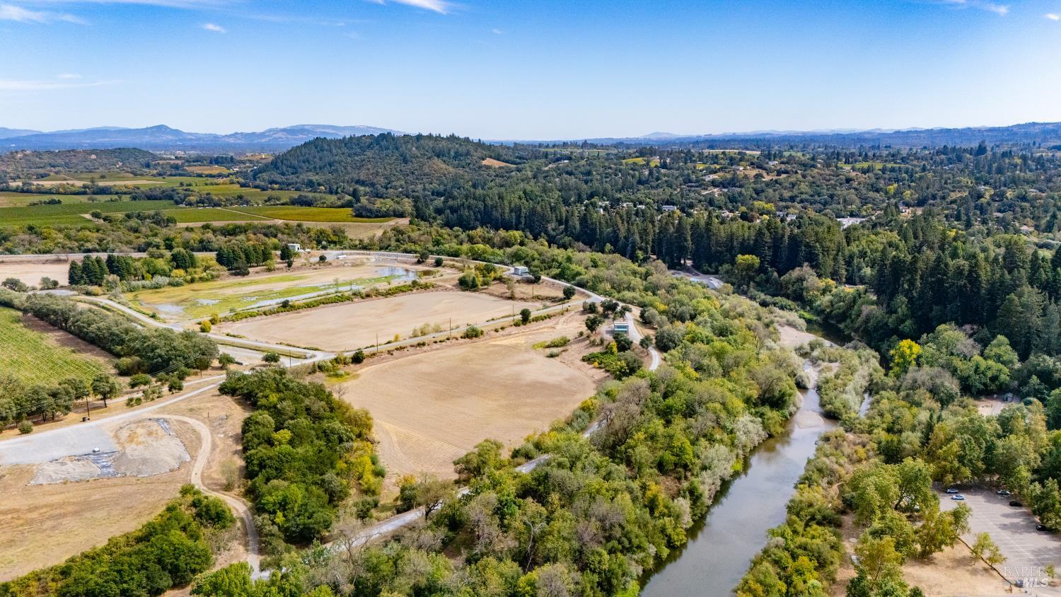 Aerial view of fields and wooded hills beside a winding river.