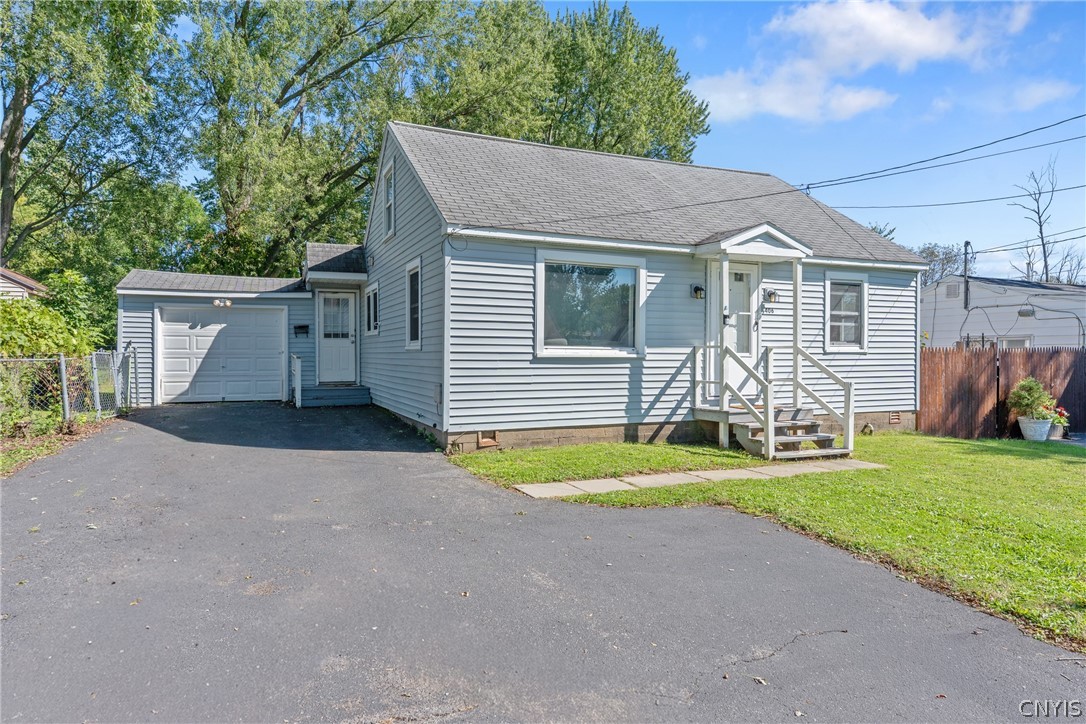 Light gray house with an attached garage, wide driveway, and small front steps.