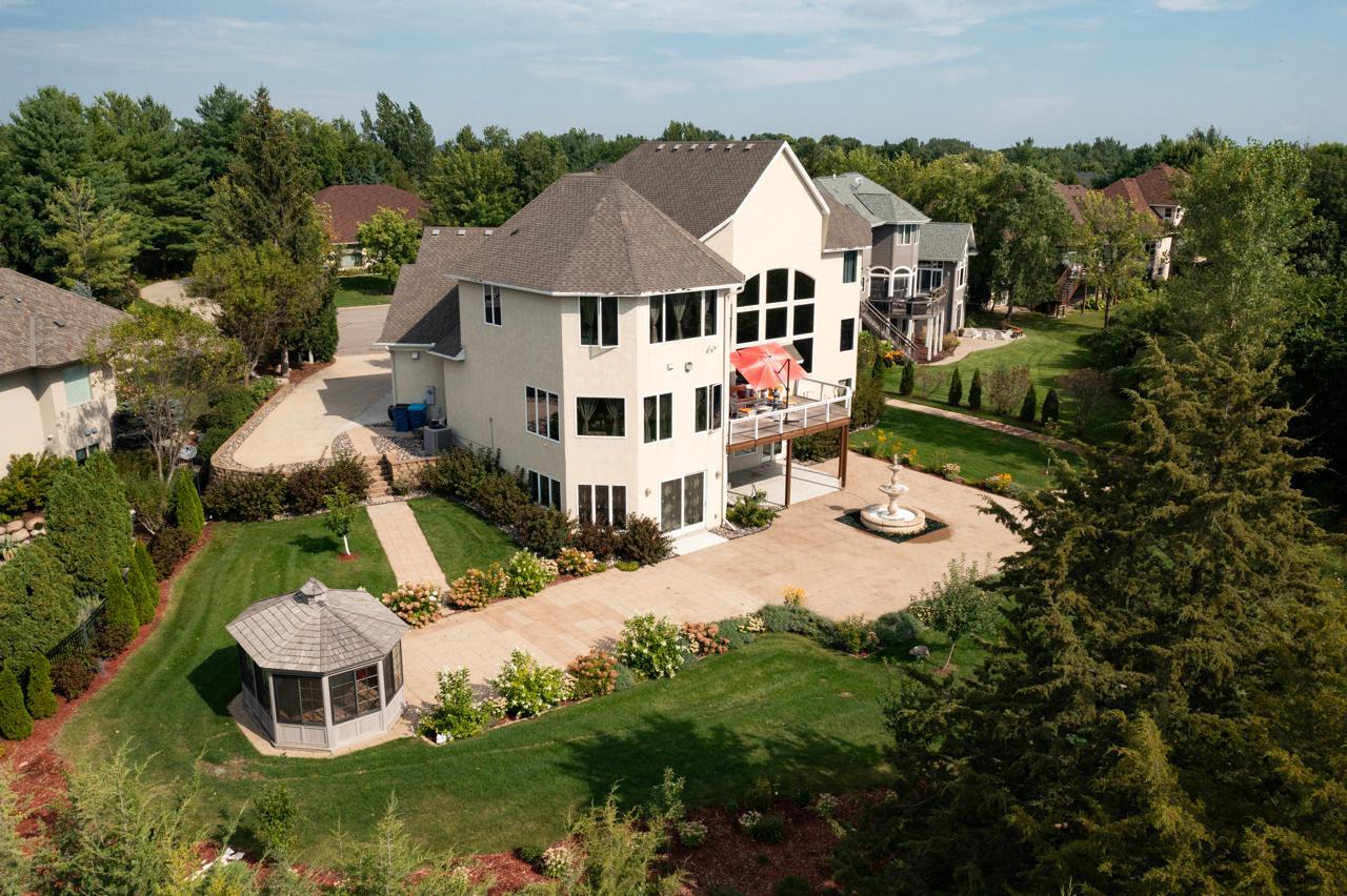 Aerial view of a large home with landscaped grounds, a fountain patio, and a gazebo.