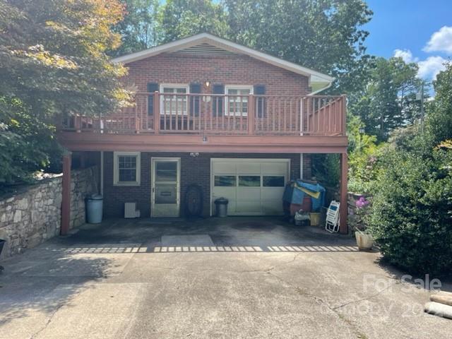 Brick two-story home with a broad raised deck above the garage and driveway.