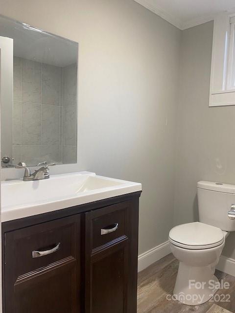 Bathroom with a dark wood vanity, white sink, large mirror, and toilet.