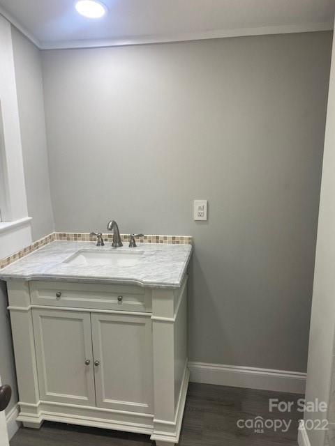Bathroom vanity with a white cabinet, marble-look countertop, and chrome faucet.