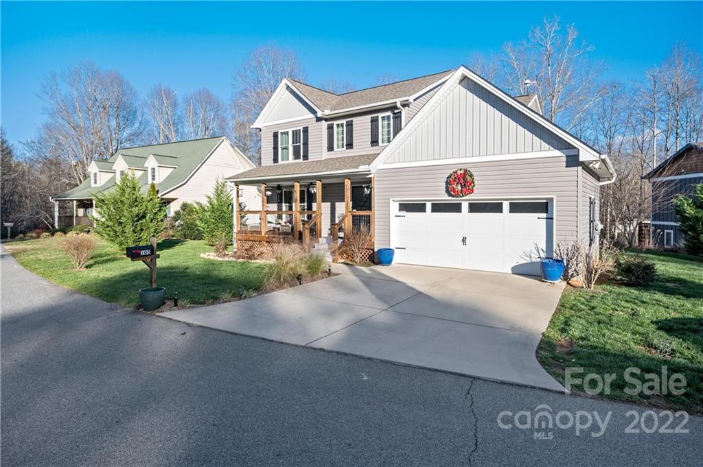 Gray two-story home with a wide driveway, covered porch, and attached two-car garage.