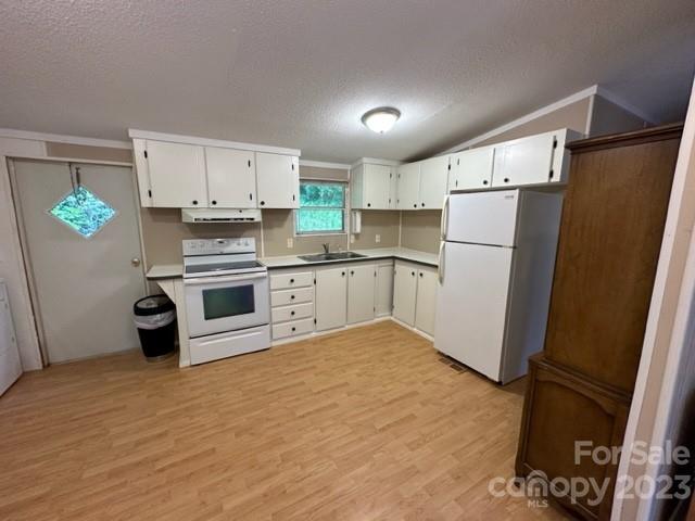 Vacant kitchen with white cabinets, electric range, refrigerator, and light wood-look flooring.