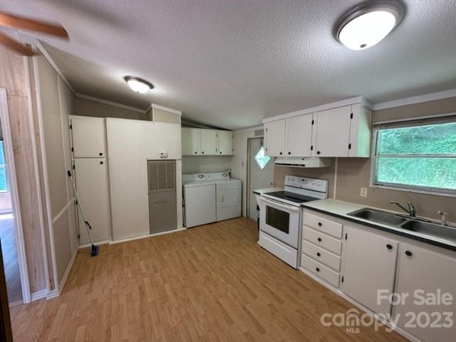Kitchen with white cabinets, a stove, double-basin sink, and washer and dryer.