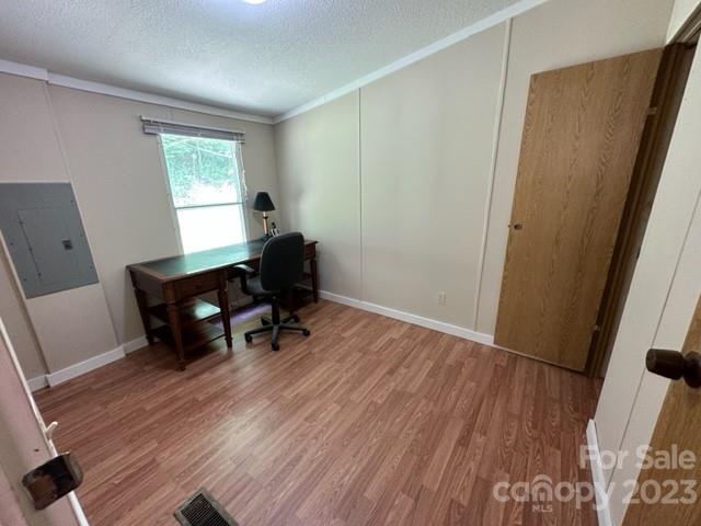 Unfurnished room with wood-look flooring and a built-in desk beside a window.