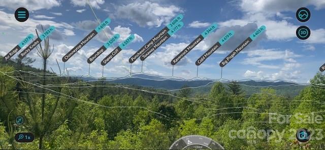 Panoramic mountain view over forested ridges, with nearby peaks labeled in the sky.