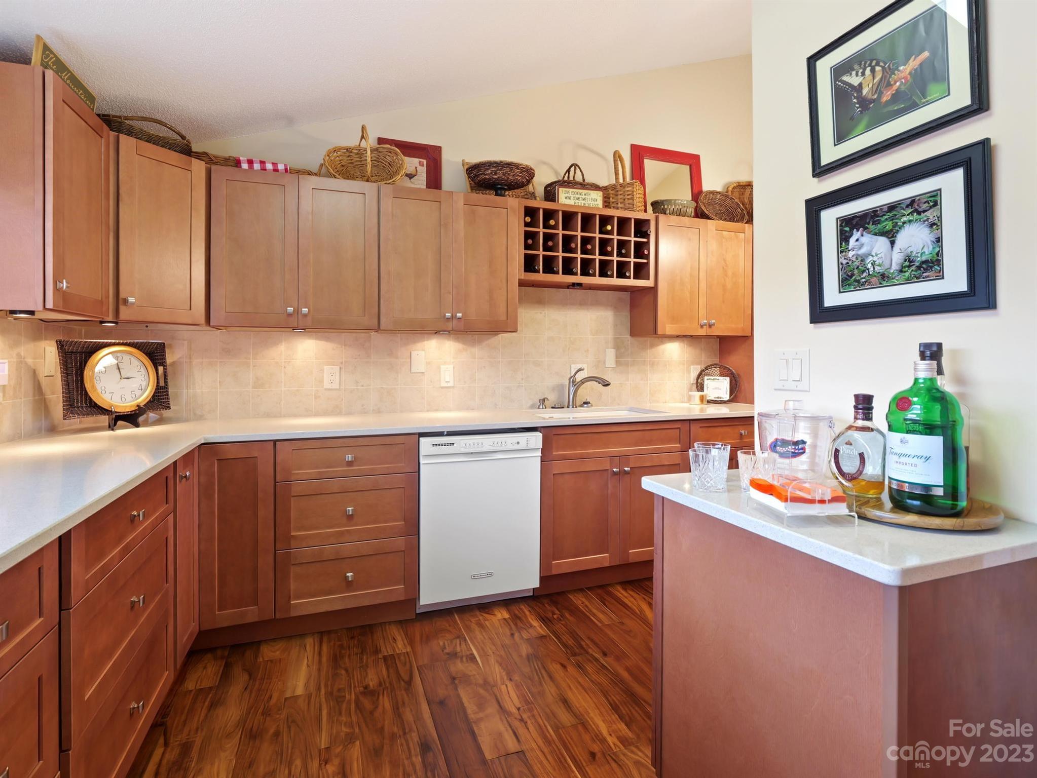 Kitchen with warm wood cabinets, a built-in wine rack, and wood-look flooring.