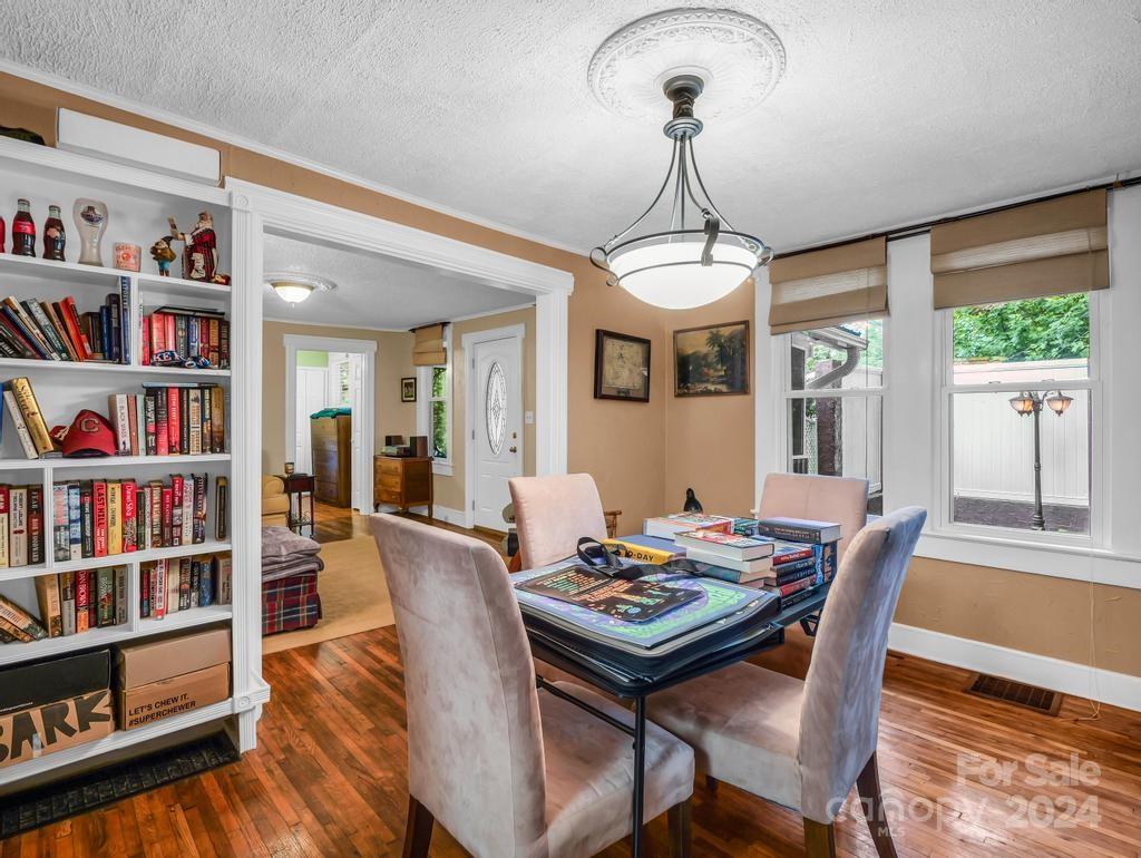 Dining room with a game-covered table, built-in bookshelves, and windows overlooking a fenced yard.